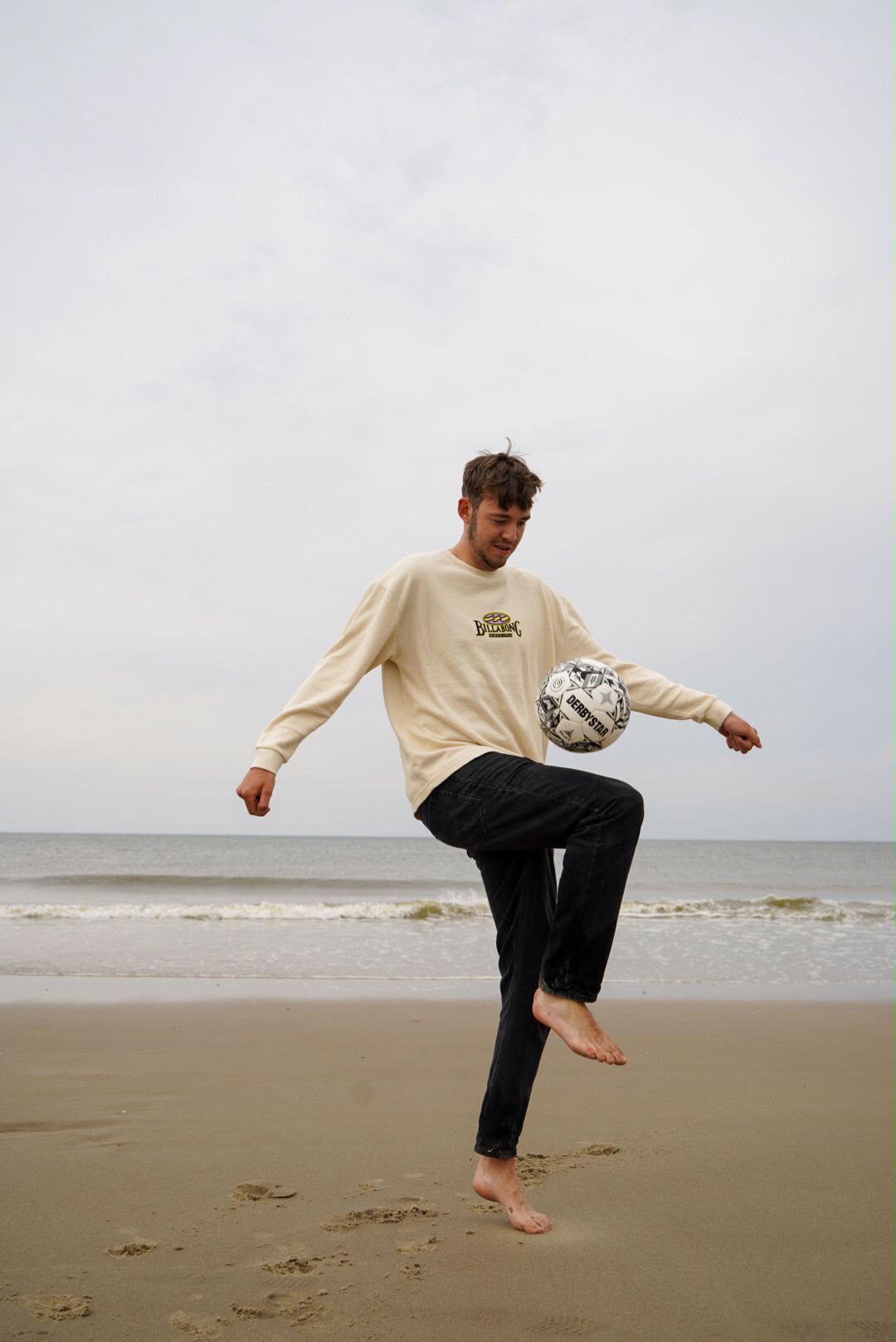 Julian playing football on the beach